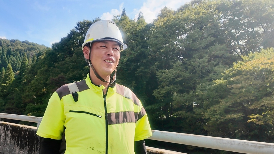 高校相撲経験で培った力を現場に活かす。施工管理の先輩社員の逞しい笑顔。